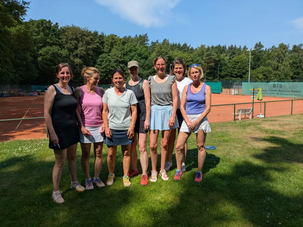 Mannschaftsfoto Damen 40: sieben Spielerinnen auf dem Rasen vor den Sandplätzen